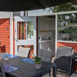 Terrace with table, chairs, and grill. Entrance to kitchen area.