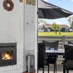 Fireplace with wood stove and outdoor terrace with table, chairs, and sun shade.
