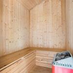 Sauna mit Holzwand und Sitzbank, Heizung mit Steinbecken.