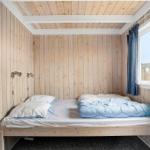 Ein Schlafzimmer mit Holzwand, Bett und Fenster mit Vorhang.