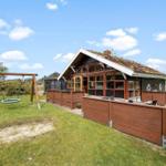 Haus mit Dachboden, Holzterrasse und Schaukel im Gras
