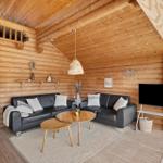 Wohnzimmer mit Holzwand, Sofa, Tisch und Fernseher