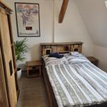 Schlafzimmer mit Doppelbett, Holzmöbel und Dachfenster.