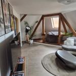 Wohnraum mit Sofa, Beistelltisch und Filmplakaten an der Wand.