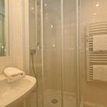 Bathroom with shower, sink, and towel rack.