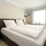 Bedroom with double bed, window, and TV.
