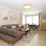 Living room with sofa, dining table, and wooden floor
