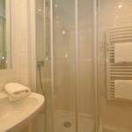 Bathroom with shower, sink, and towel rack.