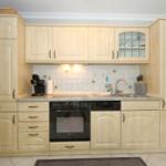 Kitchen with light cabinets, sink, stove, and refrigerator.