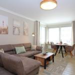 Living room with sofa, dining table, and wall art