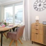 Dining table with chairs, cabinet, and wall clock in dining area.