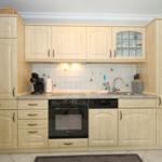Kitchen with light cabinets, sink, stove, and oven.