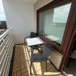 Terrasse mit Tisch und zwei Stühlen, Blick auf die Stadt.