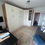 Wohnzimmer mit Sofa, TV und großen Schränken. Teppich und Beistelltisch sind sichtbar.