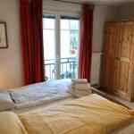 Schlafzimmer mit Doppelbett, Holzschrank und Balkon mit Blick.