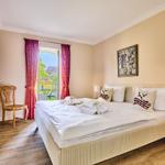 Schlafzimmer mit Bett, Nachttischen und Blick auf Garten