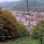 Seilbahn mit Blick auf das Dorf und die bewaldeten Berghänge.