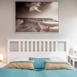 Schlafzimmer mit weißem Bett und Wandbild an der Wand