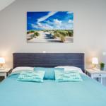 Schlafzimmer mit Bett, Nachttischen und Wandbild