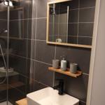 Badezimmer mit Dusche, Waschbecken und Spiegel