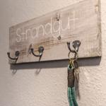 Holz-Haken mit Schriftzug Strandgut und Schlüsselanhänger an Wand
