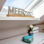Skylight with MEERZeit decor, flower in cup, stone on cabinet