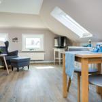 Attic apartment with dining area, seating, and skylight.