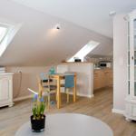 Attic apartment with dining area, kitchen, and cabinet. Skylights and wooden floor.