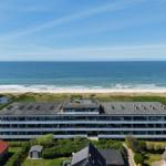 Modernes Mehrfamilienhaus mit Meerblick und Strand direkt daneben.