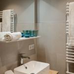 Badezimmer mit Waschbecken, Spiegel und Handtuchhalter
