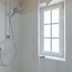Duschkabine mit Duschbrause, Fenster und Fliesenwand