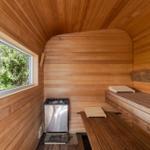 Sauna mit Holzwand, Sitzbänken und Fenster zum Garten.