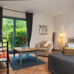 Zimmer mit Schlafbereich, Sitzgelegenheit und Blick auf den Garten.