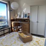 Schlafzimmer mit Schreibtisch, Kleiderschrank und Blick auf Wasser