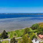 Meeresblick mit grünen Wiesen und Häusern an der Küste
