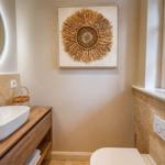 Badezimmer mit Waschtisch, Spiegel und Fenster