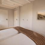 Schlafzimmer mit Bett, Kleiderschrank und Wandbild