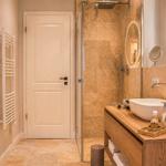 Badezimmer mit Dusche, Waschbecken und Heizkörper