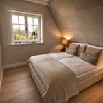 Schlafzimmer mit Dachschräge, Bett, Fenster und Wandbild