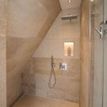 Dusche mit Glaswand, Duschbrause und Handbrause an Steinwand