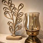 Eine dekorative Skulptur und eine goldfarbene Lampe auf einer Steinplatte.