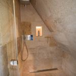 Dusche mit Steinwand und Duschbrause