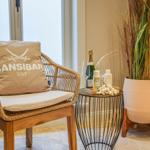 Rattan-Stuhl mit Kissen, kleiner Tisch und Pflanze in einem Raum.