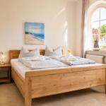 Ein Schlafzimmer mit einem Holzbett, einem Nachttisch und einem Fenster.