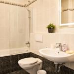 Badezimmer mit Badewanne, Duschkabine, Waschbecken und Spiegel.