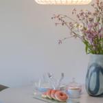 Runder Tisch mit Donuts, Blumen und Lampe. Moderne Einrichtung.