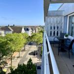 Balkon mit Tisch und Stühlen, Blick auf Straße und Häuser