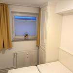 Schlafzimmer mit Fenster, Gardinen und Bett