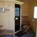 Sauna mit Holzwand, Sitzgelegenheiten und Fenster.