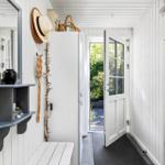 Entrance area with mirror cabinet, bench, and door to the garden.